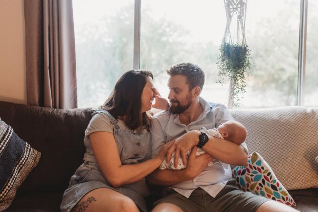 mother laughing as father holds baby with Perth newborn photographer Alana Prosper Photography