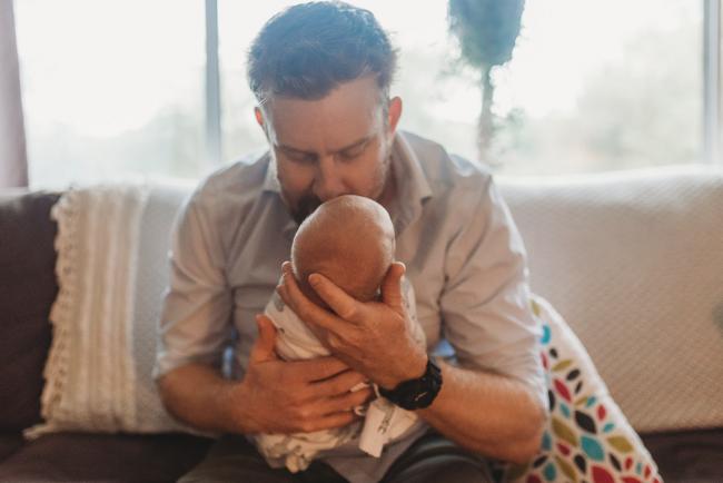 Father kissing newborn baby with Perth newborn lifestyle photographer Alana Prosper Photography