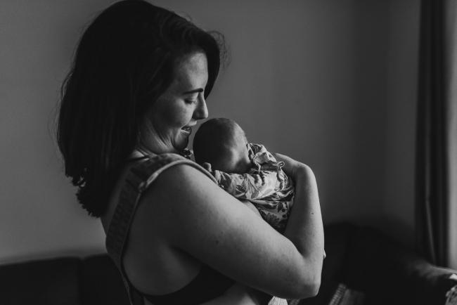 black and white image of baby on mothers chest with Perth newborn lifestyle photographer Alana Prosper Photography