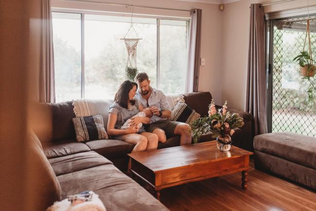 Parents on couch with newborn baby with Perth newborn lifestyle photographer Alana Prosper Photography