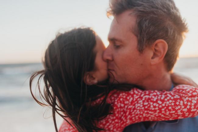 little girl hugging father who is kissing her with Perth family photographer Alana Prosper Photography at Burns Beach