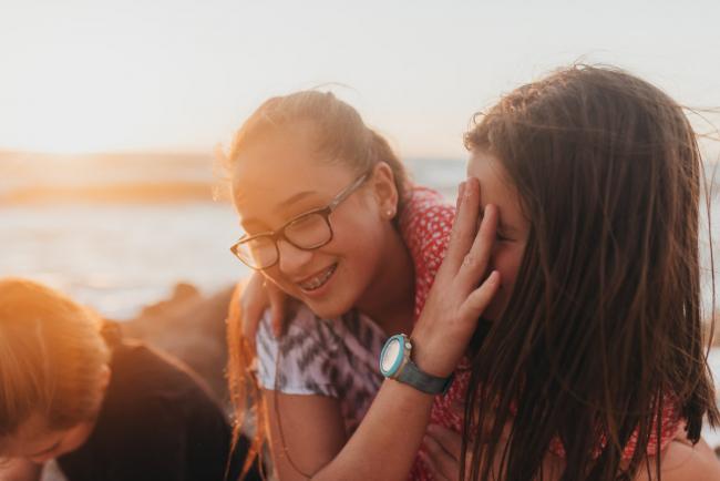 sister with hand on little sister's face with Perth family photographer Alana Prosper Photography at Burns Beach