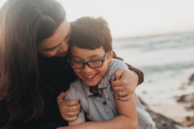 mother hugging son and both smiling with Perth family photographer Alana Prosper Photography at Burns Beach