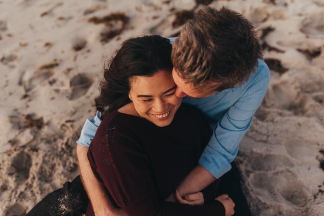 couple sitting on the sand with Perth family photographer Alana Prosper Photography at Burns Beach