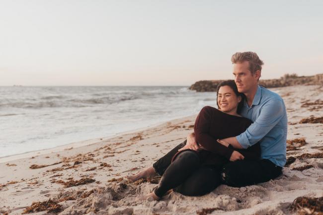 couple sitting on the sand with Perth family photographer Alana Prosper Photography at Burns Beach