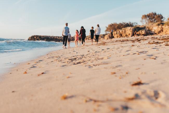 family walking along sand with Perth family photographer Alana Prosper Photography at Burns Beach