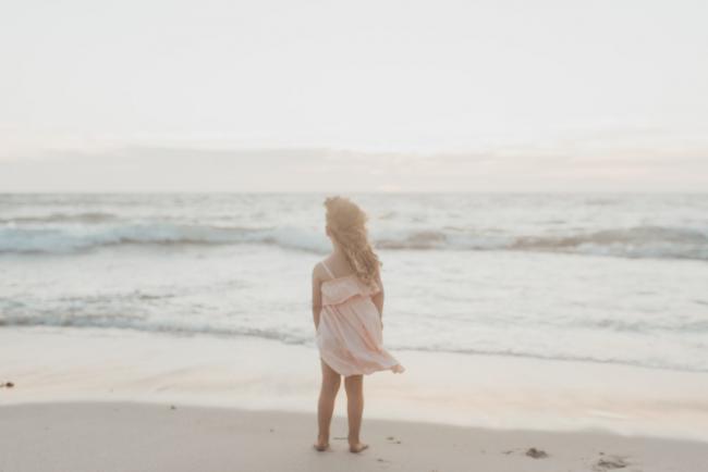 little girl looking out at the ocean with family photographer Perth at Burns Beach, Alana Prosper Photography