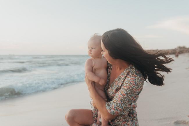mother holding baby girl on the beach with family photographer Perth at Burns Beach, Alana Prosper Photography