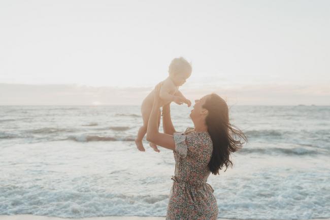 mother lifting baby on the beach with family photographer Perth at Burns Beach, Alana Prosper Photography
