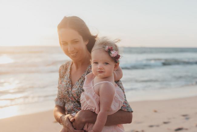mother holding baby girl on the beach with family photographer Perth at Burns Beach, Alana Prosper Photography