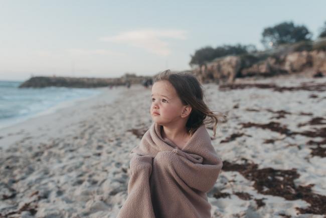 little girl with blanket on the beach with family photographer Perth at Burns Beach, Alana Prosper Photography