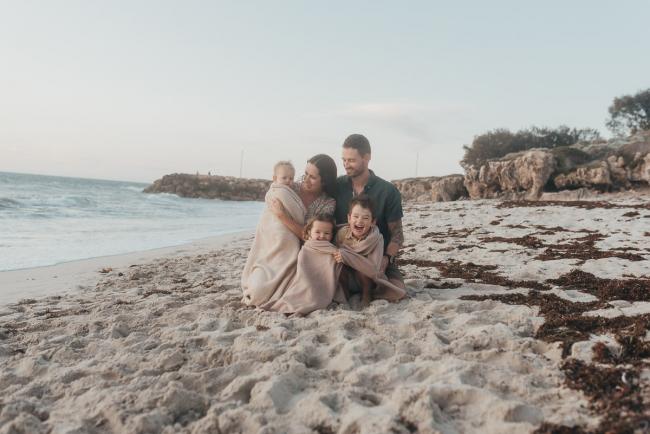 family of five on the beach with blanket with family photographer Perth at Burns Beach, Alana Prosper Photography