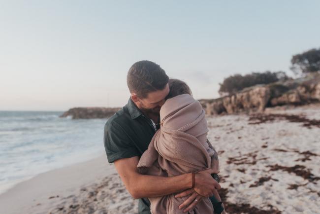 father holding daughter in blanket with family photographer Perth at Burns Beach, Alana Prosper Photography