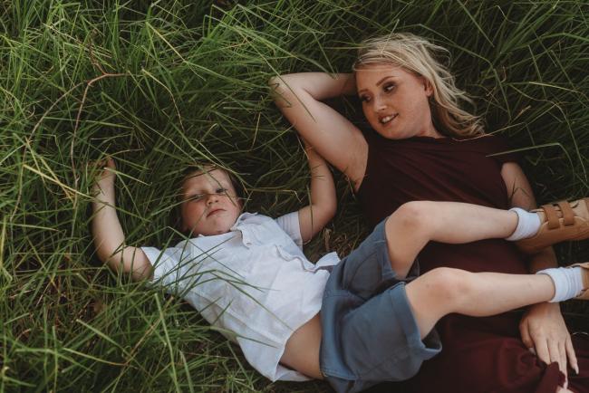 mother and son laying in grass during golden hour at Perry's Paddock with Perth Family Photographer Alana Prosper Photography