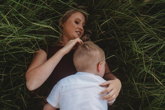 mother and son laying in grass during golden hour at Perry's Paddock with Perth Family Photographer Alana Prosper Photography
