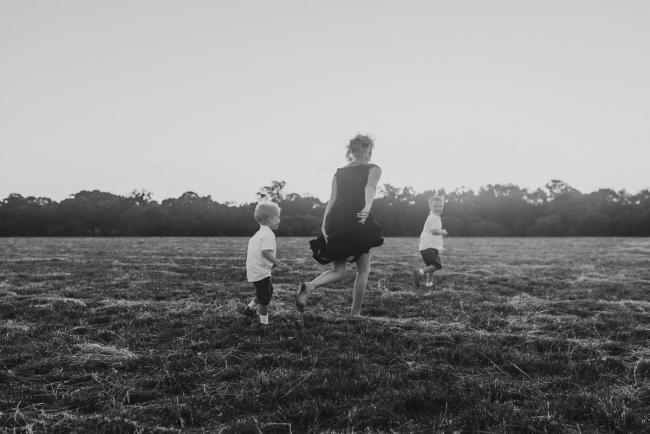 black and white image of mother running with sons during golden hour at Perry's Paddock with Perth Family Photographer Alana Prosper Photography