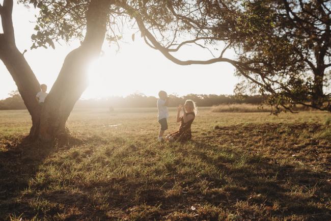 mother and son playing a game on the ground during golden hour at Perry's Paddock with Perth Family Photographer Alana Prosper Photography