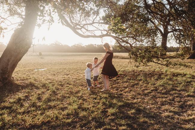 mother playing ring a rosy with two sons during golden hour at Perry's Paddock with Perth Family Photographer Alana Prosper Photography