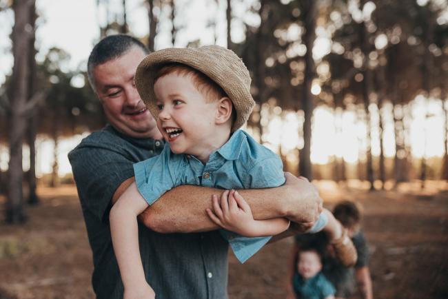 father flying little boy through the air during Perth family photography session at The Pines Perth with Alana Prosper Photography