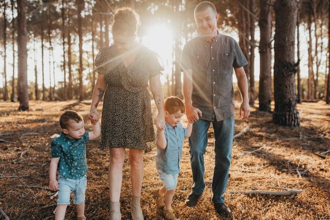 Family holding hands and walking during golden hour during Perth family photography session at The Pines Perth with Alana Prosper Photography