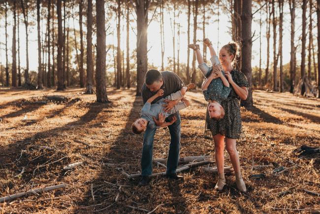 parents holding sons upside down during Perth family photography session at The Pines Perth with Alana Prosper Photography