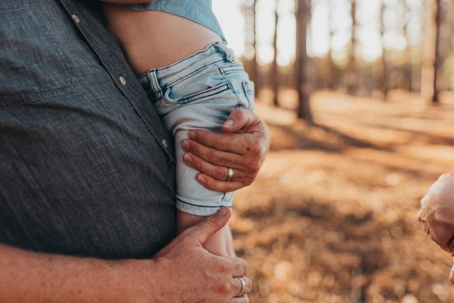 Fathers hands around sons waist during Perth family photography session at The Pines Perth with Alana Prosper Photography