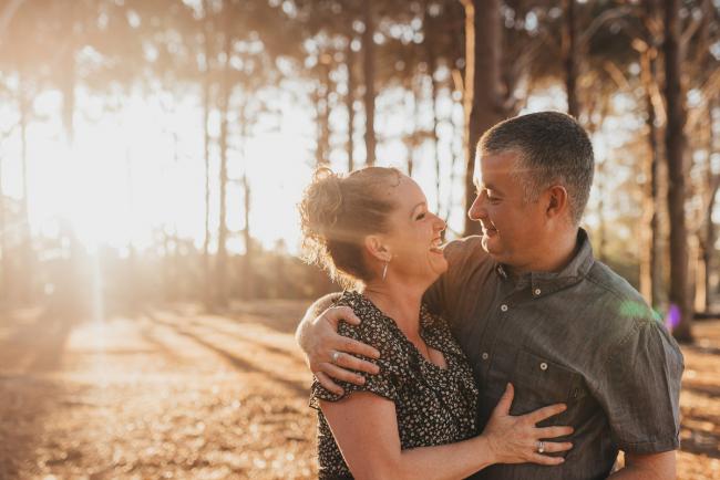 Couple hugging in golden hour during Perth family photography session at The Pines Perth with Alana Prosper Photography