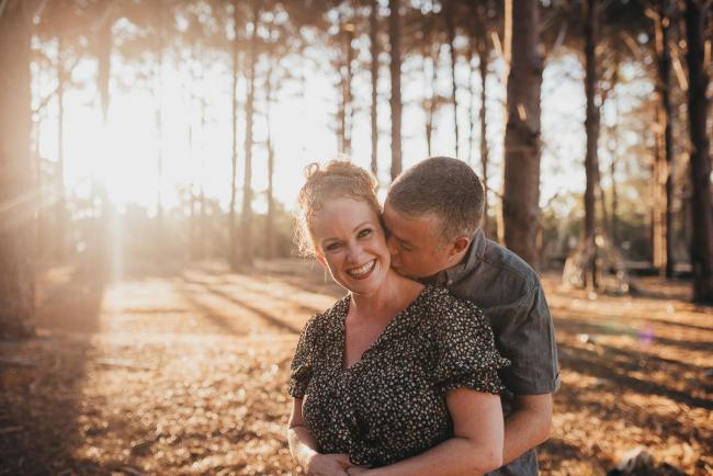 Husband kissing wifes neck during Perth family photography session at The Pines Perth with Alana Prosper Photography