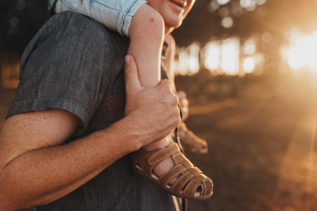 father holding onto sons legs who is on his shoulder during Perth family photography session at The Pines Perth with Alana Prosper Photography