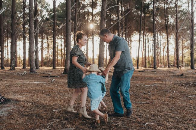 Family of four playing ring a rosy during Perth family photography session at The Pines Perth with Alana Prosper Photography