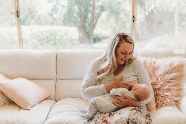 mother breastfeeding baby on couch with Perth lifestyle newborn photographer Alana Prosper Photography