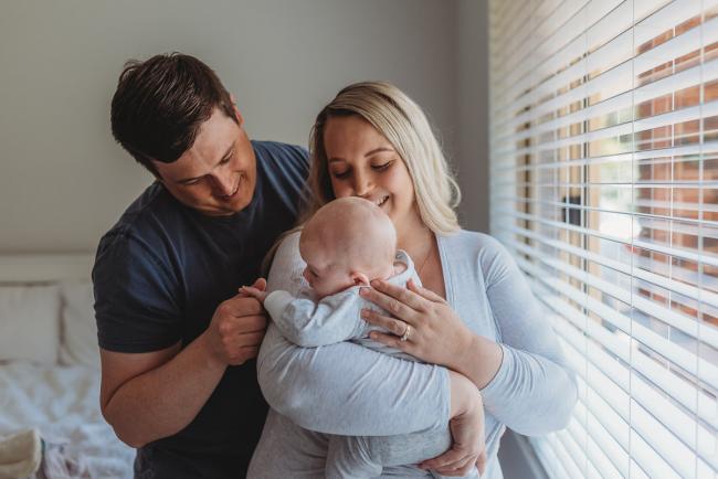 Perth-Newborn-Photographer-Alana-Prosper-Photography-17-of-31 mother and father holding baby by window with Perth lifestyle newborn photographer Alana Prosper Photography