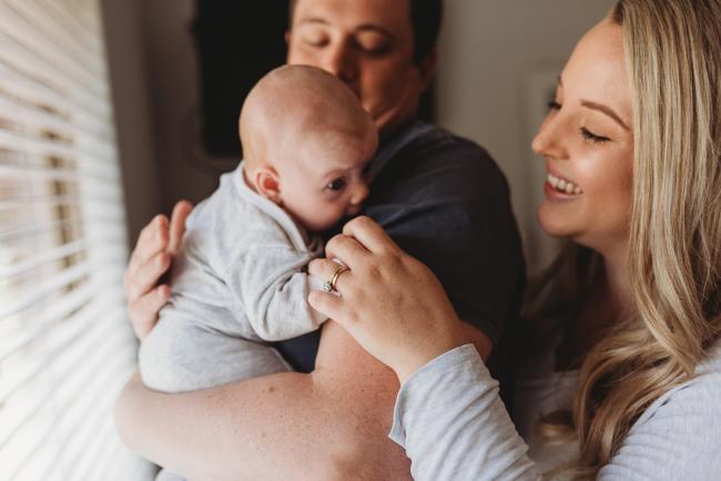 Perth-Newborn-Photographer-Alana-Prosper-Photography-20-of-31 dad holding baby with mother touching hand with Perth lifestyle newborn photographer Alana Prosper Photography