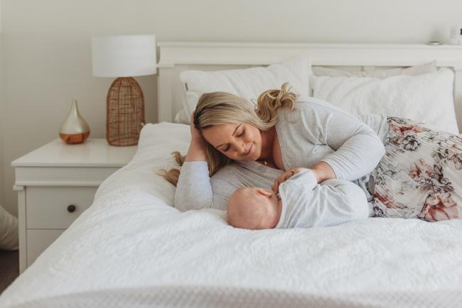 mother laying on bed with baby with Perth lifestyle newborn photographer Alana Prosper Photography