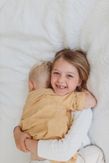 Perth-Newborn-Photographer-Alana-Prosper-Photography-6-of-31 brother laying on sister who is smiling with Perth lifestyle newborn photographer Alana Prosper Photography