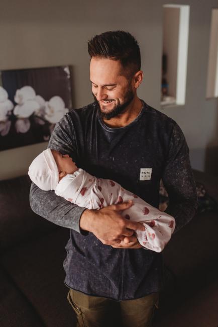 Father holding newborn baby with Perth newborn lifestyle photographer