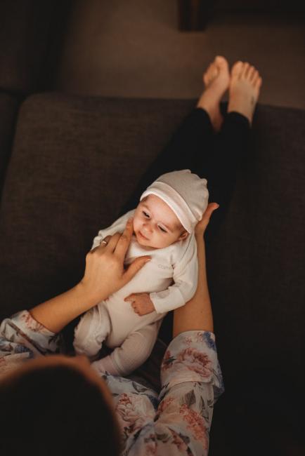 Mother holding baby on lap with Perth newborn lifestyle photographer