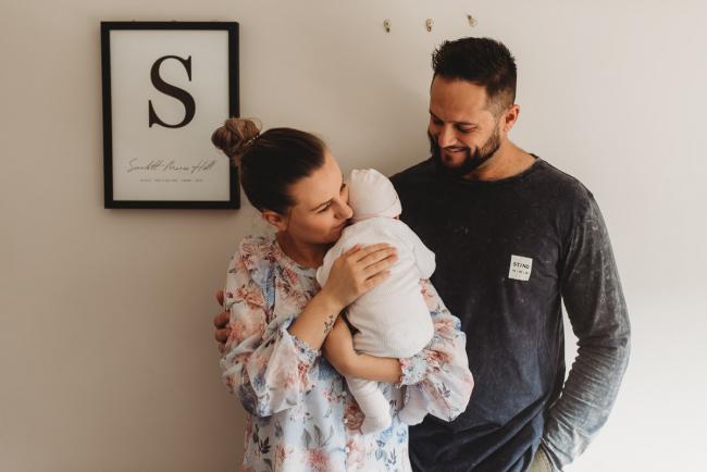 Parents holding newborn baby with Perth newborn lifestyle photographer