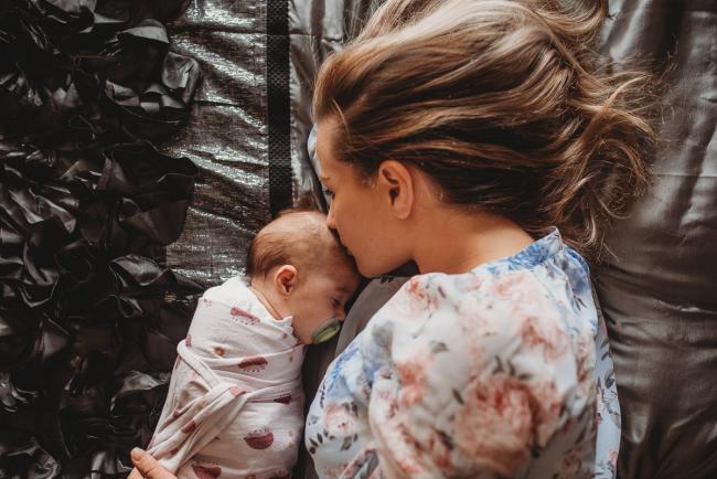 mother laying on bed with baby with Perth lifestyle newborn photographer Alana Prosper Photography