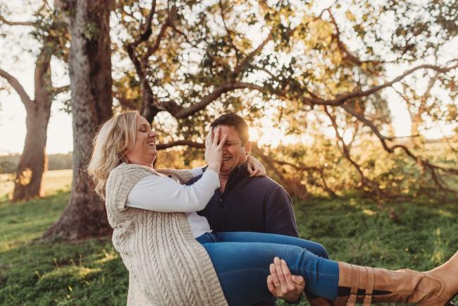 husband lifting wife while she puts hand on his face with Perth family photographer Alana Prosper Photography at Perry's Paddock